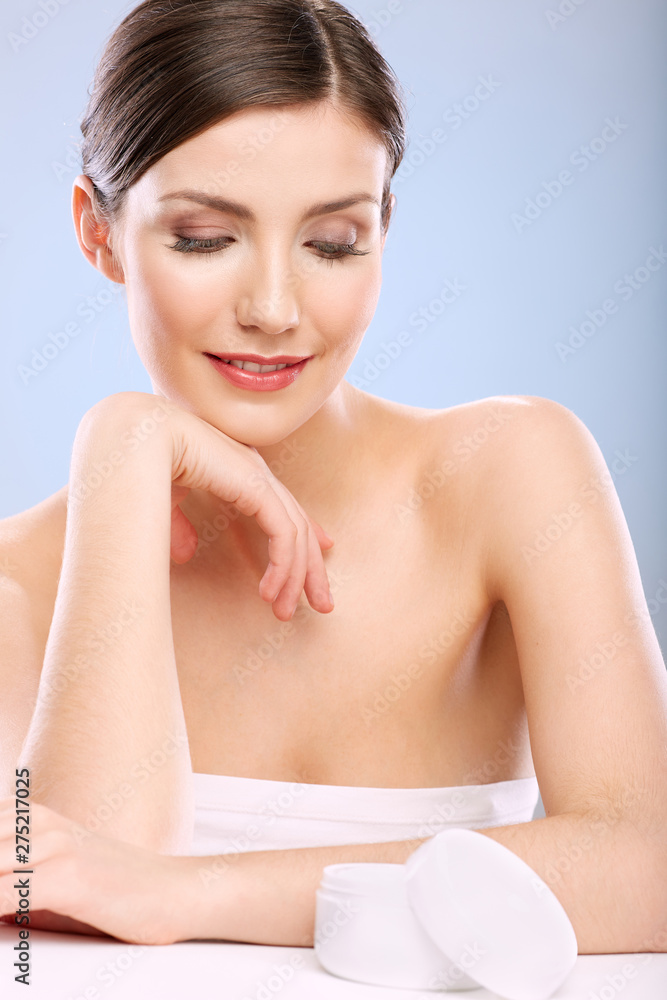 Skin care concept portrait with young woman looking down at cream jar. Skin care concept portrait with young woman looking down at cream jar.