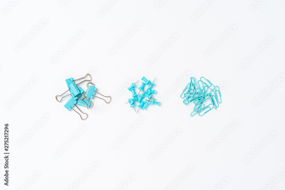 Various kinds of paper clips and drawing pins. Top view