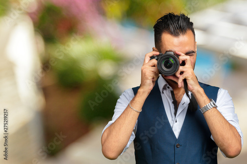 east asian handsome man taking a shot with camera
