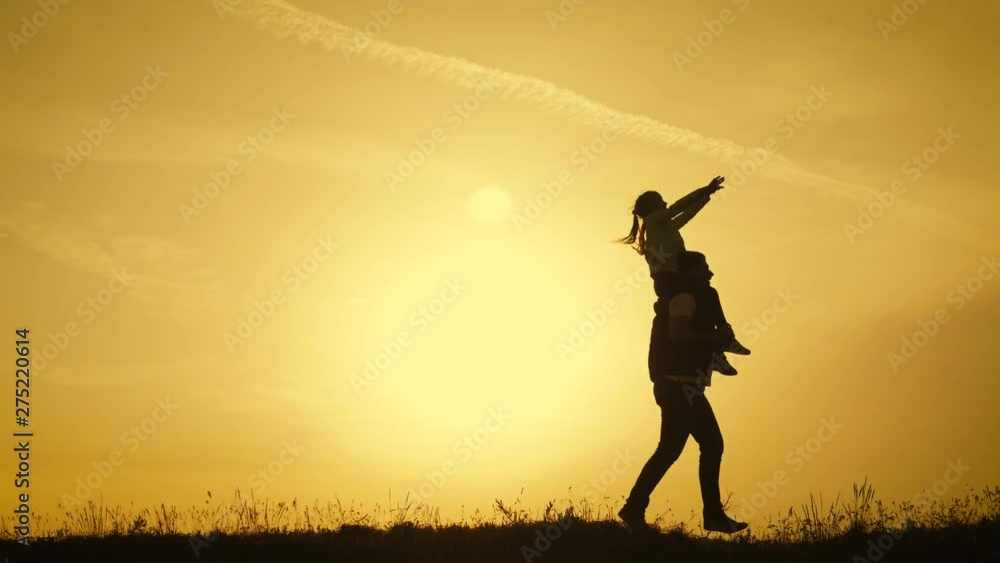 Happy family playing with a kite while on meadow, sunset, in summer day. Funny family time. Happy little girl launch a kite with parents. Mom, Dad and daughter are happy together. Happy family playing with a kite while on meadow, sunset, in summer day. Funny family time. Happy little girl launch a kite with parents. Mom, Dad and daughter are happy together.
