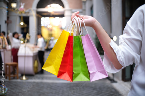 Asian girls holding sale shopping bags. consumerism lifestyle concept in the shopping mall.