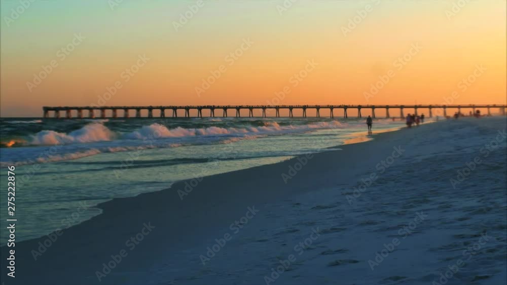 Locals and tourists walk the beach as the day comes to an end in this small beach town time lapse Locals and tourists walk the beach as the day comes to an end in this small beach town time lapse