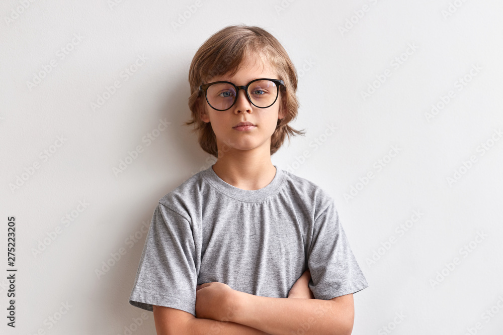 Serious schoolboy looking at camera