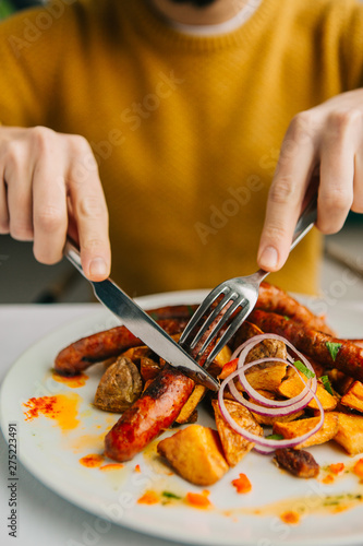 Close up of man eating sausages 