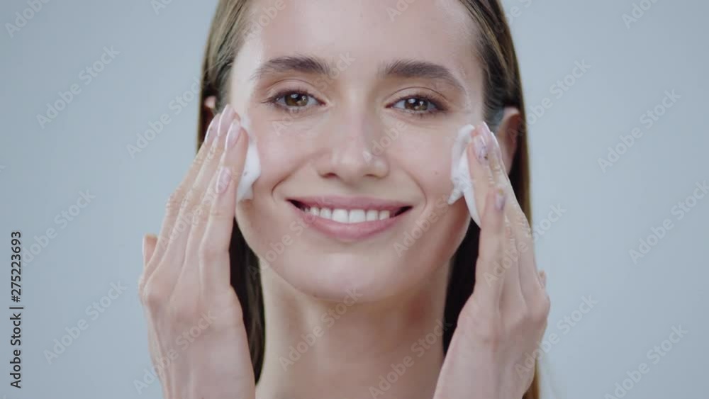 Portrait young woman uses creams for the beauty of her face daytime and night-time concept for fresh moisturized skin beautiful closeup cosmetic face happy health healthy isolated model slow motion
