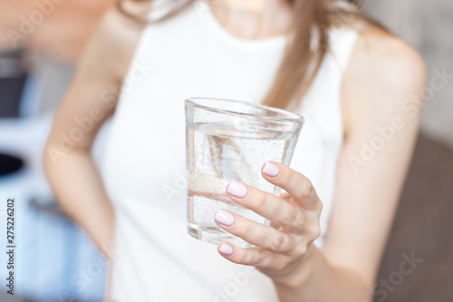 Close-up woman with slim body holding a glass of water, rear veaw