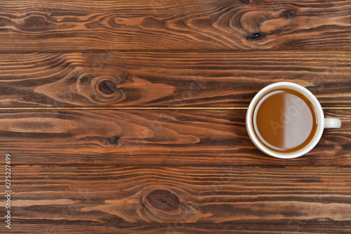 Cup of coffee on a brown wooden background