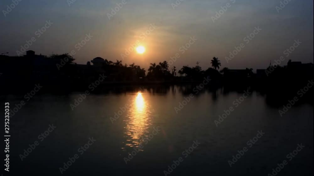 Sunset time lapse at lakeside and shadow of sun in water in evening time Sunset time lapse at lakeside and shadow of sun in water in evening time