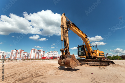 Excavator on a construction site against a blue sky. Construction, technology