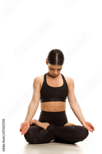 Young woman siting in lotus yoga position and yoga breathing on white background 