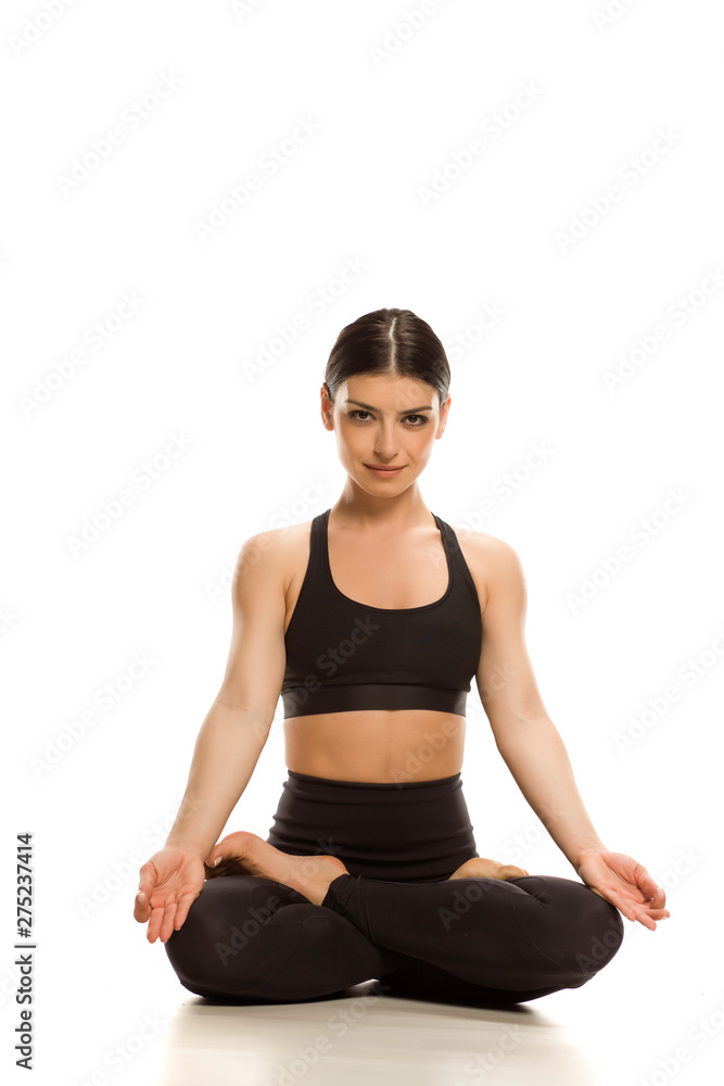 Young yoga woman siting in lotus position on white background Young yoga woman siting in lotus position on white background