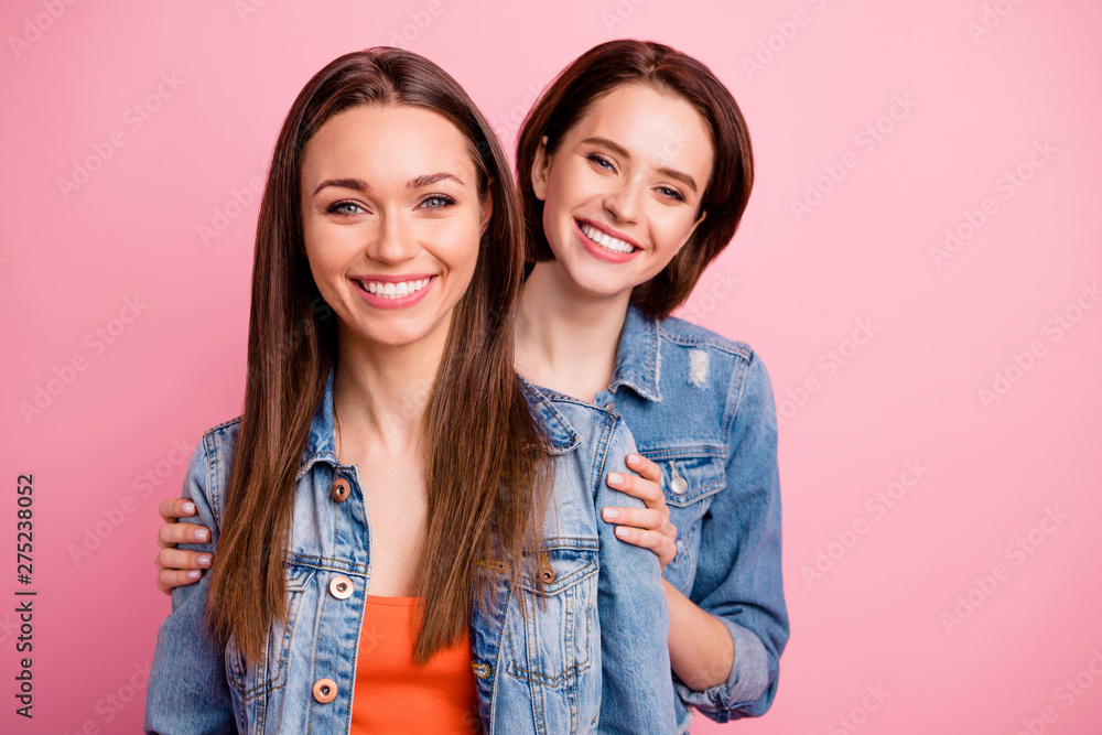 Close up photo two beautiful funky sisters she her festive ladies pretty appearance party chill mood hugging back piggy back wear jeans denim jackets blazers isolated bright pink background Close up photo two beautiful funky sisters she her festive ladies pretty appearance party chill mood hugging back piggy back wear jeans denim jackets blazers isolated bright pink background