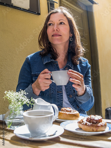 Enjoying Kanelbulle and coffee at outdoor cafe in Stockholm
