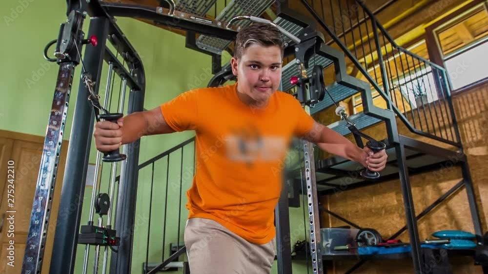 A young man is trying hard to do this exercise well. He is working out for his arms. A young man is trying hard to do this exercise well. He is working out for his arms.