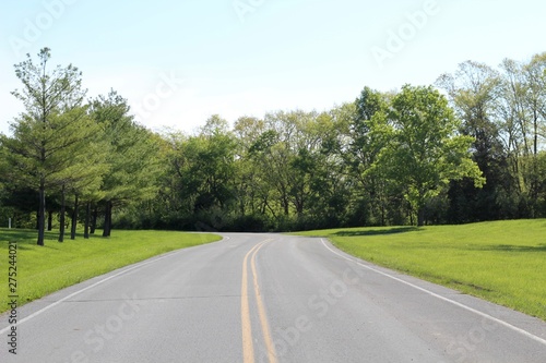 A long empty road up the hill in the countryside.