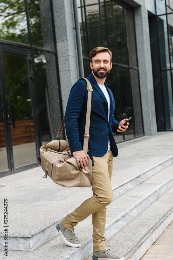 Attractive young bearded man wearing jacket walking