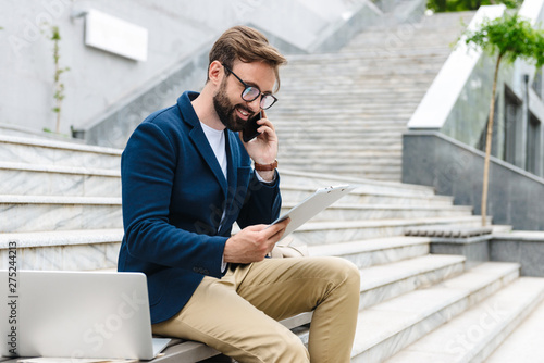 Handsome smiling young bearded man wearing jacket photo