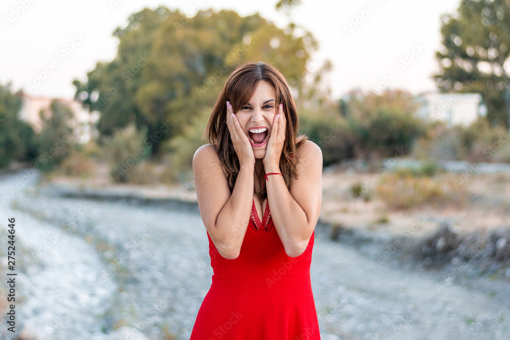 very stressed and surprised young woman in a red dress
