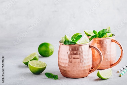Fotografía Moscow mule ice cold cocktail in copper cup with lime and and mint on gray stone