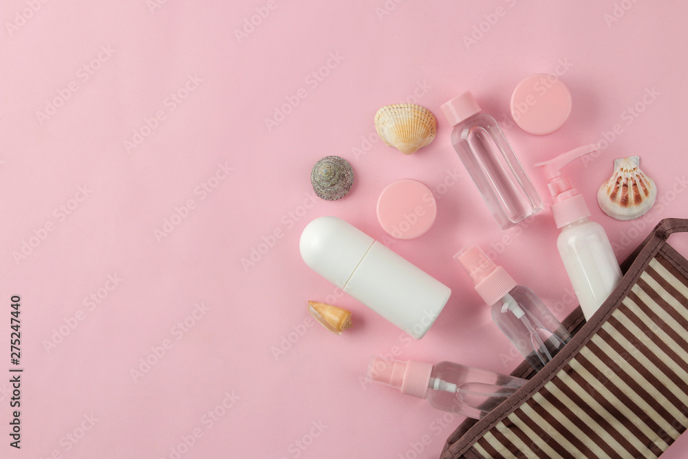 A set of cosmetics and personal care products for travel in a cosmetic bag on a light pink background. top view. travel cosmetics A set of cosmetics and personal care products for travel in a cosmetic bag on a light pink background. top view. travel cosmetics