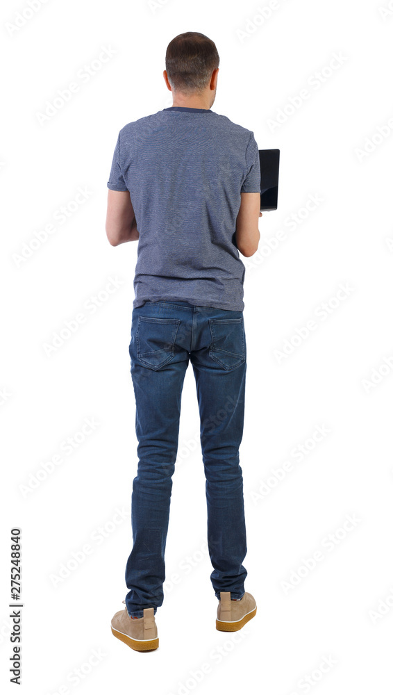 Back view of a man who is standing with a laptop. Back view of a man who is standing with a laptop.