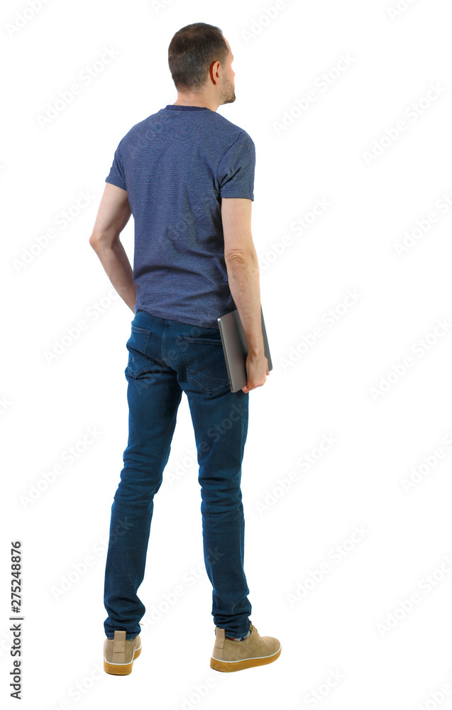 Back view of a man who is standing with a laptop. Back view of a man who is standing with a laptop.