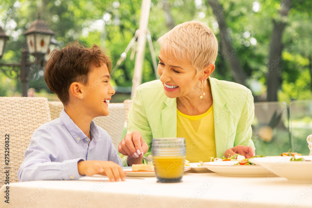 Handsome dark-haired boy having breakfast with granny Handsome dark-haired boy having breakfast with granny
