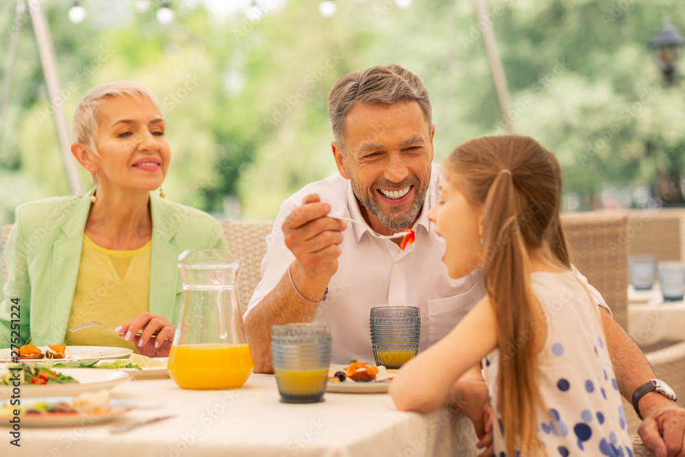 Bearded granddad feeding his lovely cute girl Bearded granddad feeding his lovely cute girl