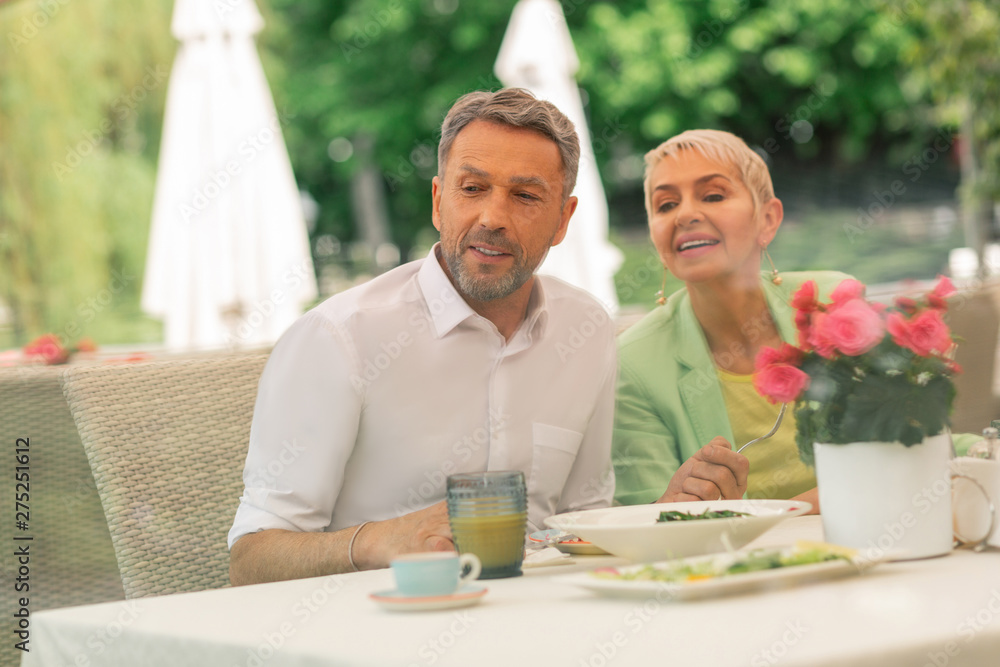 Grey-haired handsome husband having breakfast with beautiful wife