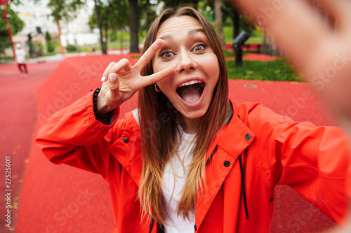 Chherful attractive young girl wearing raincoat