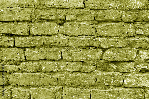 Old grungy brick wall texture in yellow tone.