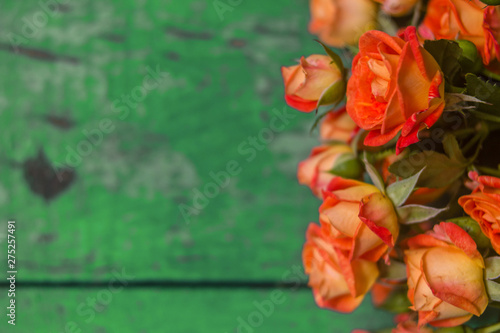Fototapeta Naklejka Na Ścianę i Meble -  Orange roses on vintage wooden geen background.