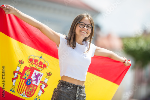 Photography Happy girl tourist walking in the street with spanish flag