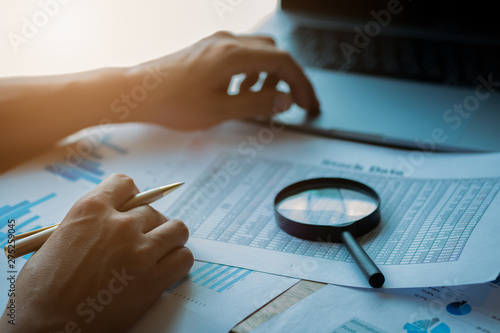 man looking through a magnifying glass to documents. Business assessment and audit. Magnifying glass on a financial report. Close-up Of Checking Bills With Magnifying Glass.Concept of search. photo