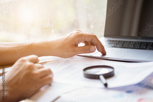 man looking through a magnifying glass to documents. Business assessment and audit. Magnifying glass on a financial report. Close-up Of Checking Bills With Magnifying Glass.Concept of search.