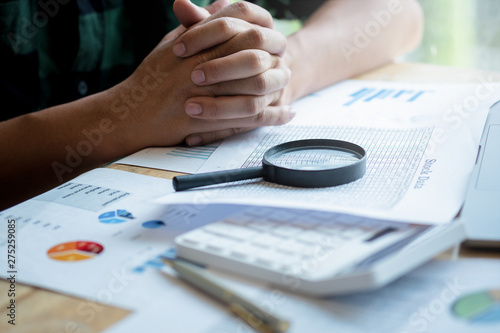 man looking through a magnifying glass to documents. Business assessment and audit. Magnifying glass on a financial report. Close-up Of Checking Bills With Magnifying Glass.Concept of search.