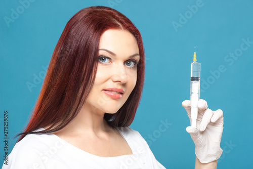 beautiful woman doctor cosmetologist holding syringe with solution for beauty injections. isolated female studio portrait.