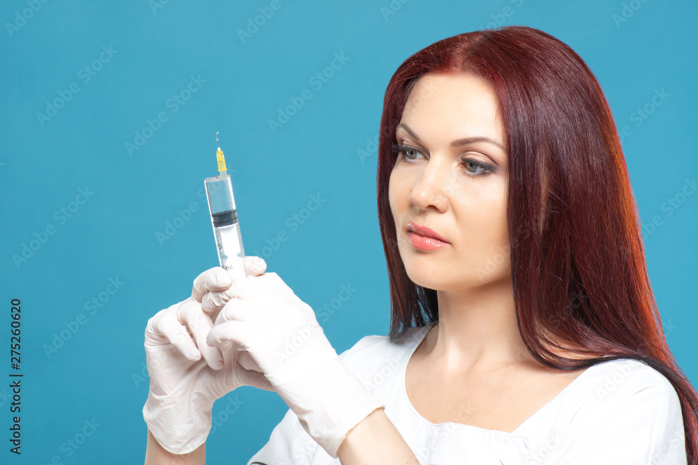 Obraz premium beautiful woman doctor cosmetologist holding syringe with solution for beauty injections. isolated female studio portrait.