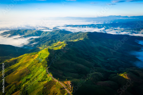 aerial view road way on the green mountain peak in the rain season and morning mist and blue sky background © SHUTTER DIN