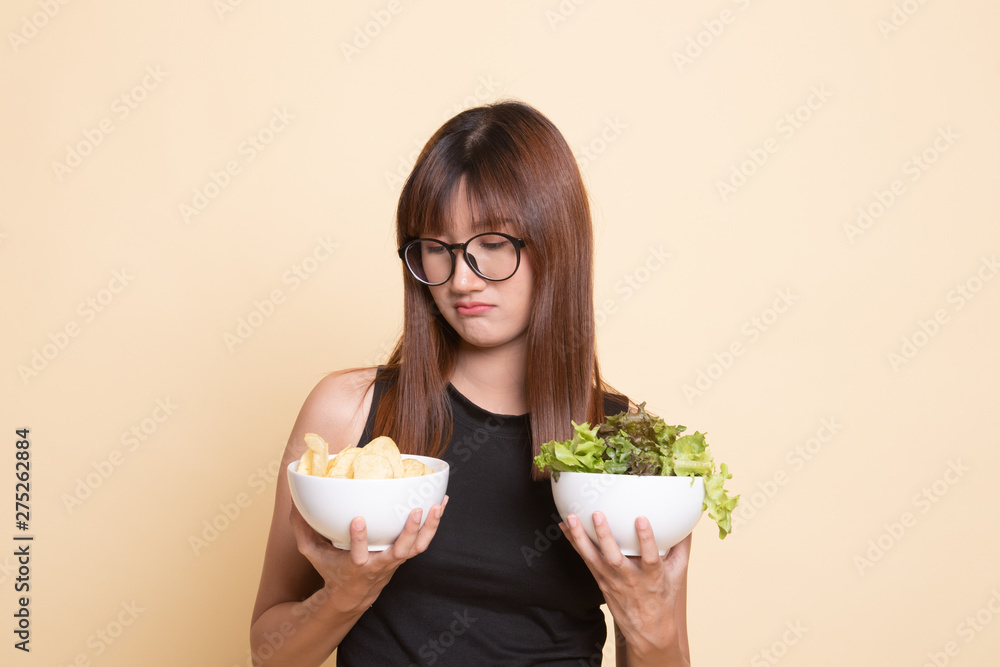 Young Asian woman with potato chips and salad. Young Asian woman with potato chips and salad.