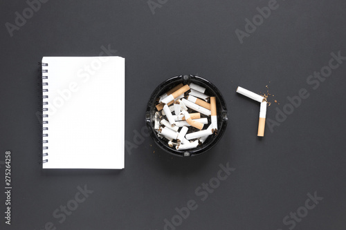 Top view pile of cigarettes with notebook photo