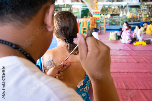 Wallpaper Mural Master makes traditional Yantra tattoo on magic tattoo Sak Yant holiday. Thailand. Torontodigital.ca