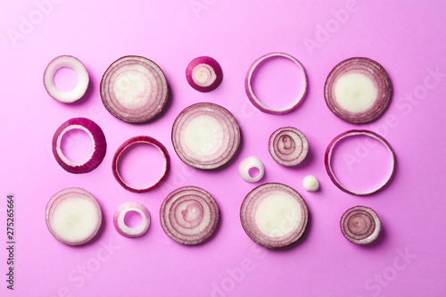 Flat lay composition with red onion rings on color background