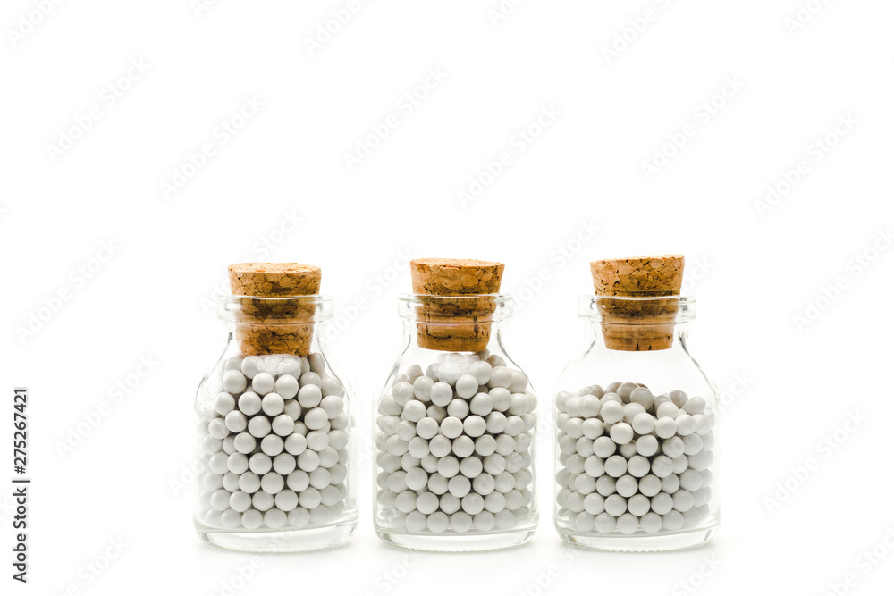 glass bottles with round pills and wooden corks isolated on white glass bottles with round pills and wooden corks isolated on white