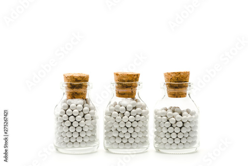glass bottles with round pills and wooden corks isolated on white