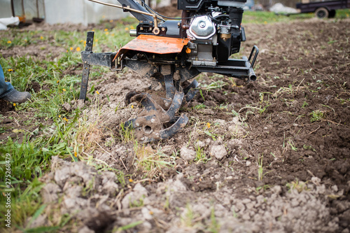 Agricultural machinery: cultivator for tillage in the garden. Preparing the land for planting vegetables with the help of a cultivator.