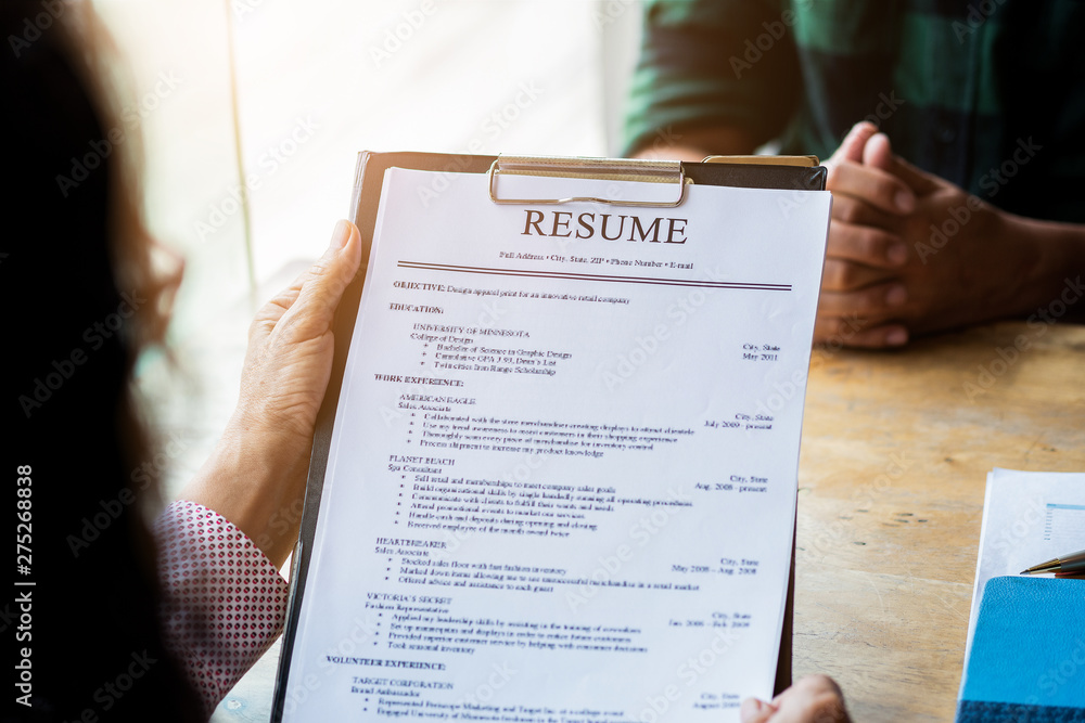 Obraz premium Interviewer reading a resume, Person submits job application, Person describe yourself to interviewer, focus on resume, recruiter considering application, hr manager making hiring decision