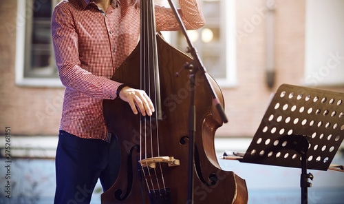 Bilde på lerret A professional musician, dressed in a pink plaid shirt and blue pants, plays a j