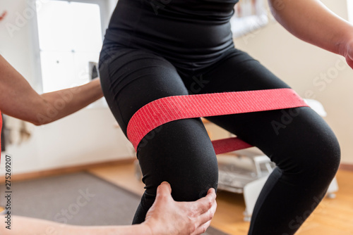 Physiotherapist doing with girl exercise for knee