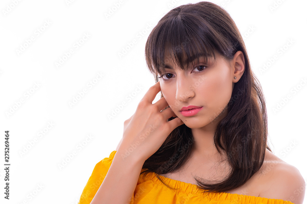 Portrait of Attractive Young Female Model. The girl poses with a yellow dress in a studio with a white background. Portrait of Attractive Young Female Model. The girl poses with a yellow dress in a studio with a white background.
